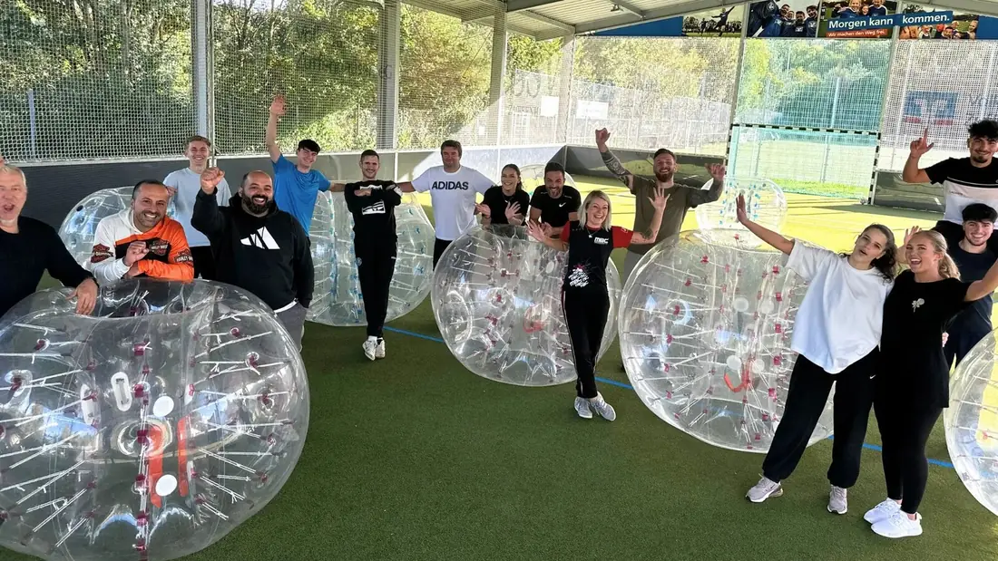 Firmengruppe beim Bubble Soccer, betreut von einem Eventleiter