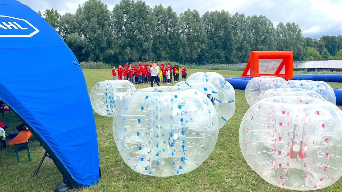 Firmengruppe beim Bubble Soccer, betreut von einem Eventleiter